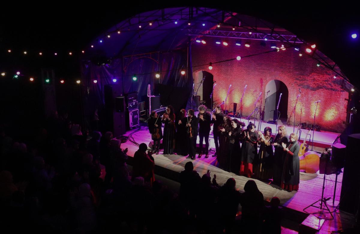 Een festivalpodium bij avond met veel publiek