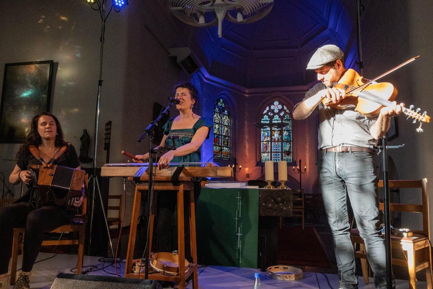 Drie muzikanten spelen in een kapel