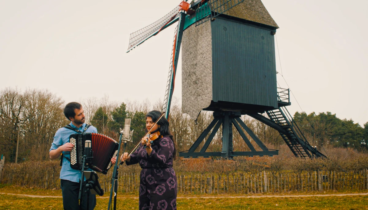 Twee muzikanten met accordeon bij een windmolen